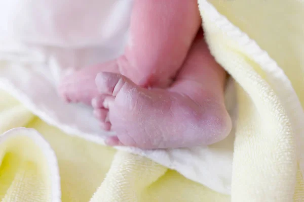 Feet of Newborn baby child seconds and minutes after birth lying on towel — Stock Photo, Image