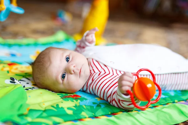 Carino adorabile neonato che gioca sulla colorata palestra giocattolo — Foto Stock