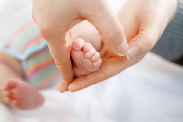 Padre o madre sosteniendo el pie del bebé recién nacido — Foto de Stock