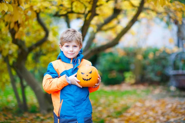 幸せなかわいい子供を持った少年ハロウィーン カボチャのランタン 楽しんで 寒い秋の日秋の庭や公園を再生のカラフルな服で面白い子 — ストック写真