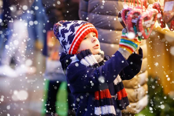 Pequeno garoto bonito menino comprando doces de um stand de cancy no mercado de Natal — Fotografia de Stock