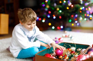 Güzel çocuk ve renkli eski yılbaşı oyuncakları ve topları. Çocuk Noel ağacı süslemesi