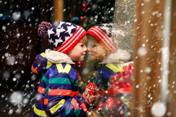 Zabawne szczęśliwe dziecko w ubrania zimowe moda co zakupy okno udekorowane prezenty, Boże Narodzenie drzewo — Zdjęcie stockowe
