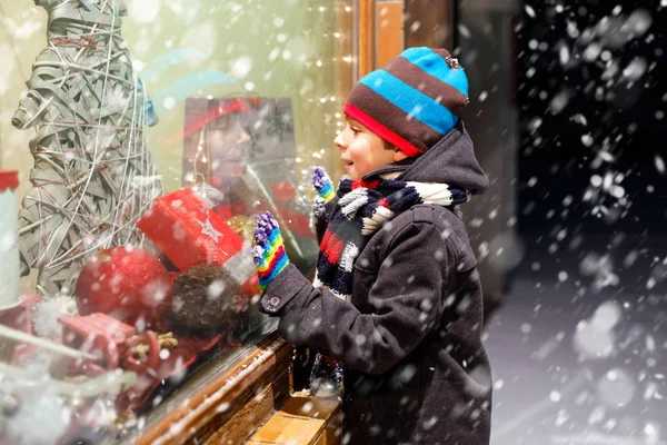 Lustige glückliche Kind in Mode Winterkleidung machen Schaufensterbummel mit Geschenken dekoriert, Weihnachtsbaum — Stockfoto