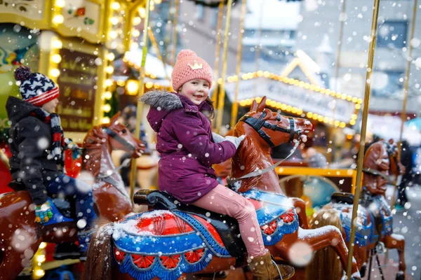 可爱的小女孩骑在旋转木马圣诞游乐场或市场, 户外. — 图库照片
