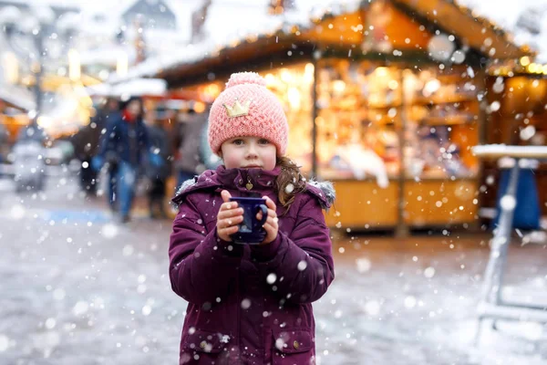 Маленькая девочка с горячим шоколадом на рождественской ярмарке — стоковое фото