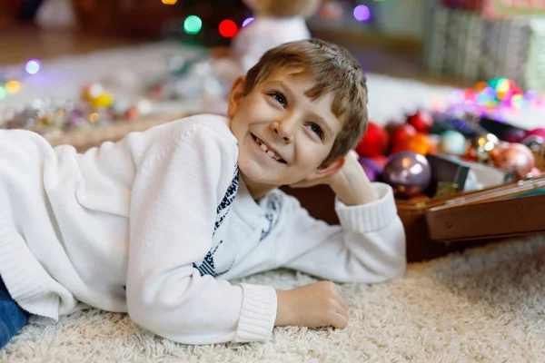 Güzel çocuk ve renkli eski Noel oyuncakları ve top eski bavulda..