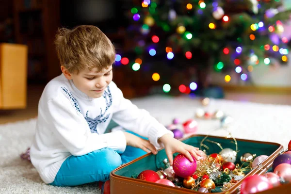 Güzel çocuk ve renkli eski yılbaşı oyuncakları ve topları. Çocuk Noel ağacı süslemesi