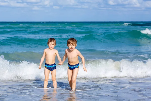 Ocean beach Florida üzerinde çalışan iki çocuk çocuklar