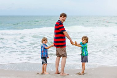 İki küçük çocuk çocuklar ve babası okyanus plaj