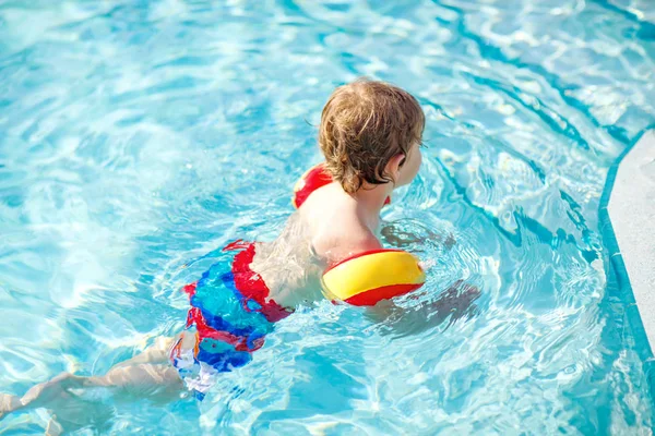 Mutlu küçük çocuk çocuk yüzme havuzuna eğleniyor. Yüzmeyi öğrenme etkin mutlu bir çocuk. güvenli floaties veya swimmies ile. Aile, tatil, yaz konsepti — Stok fotoğraf