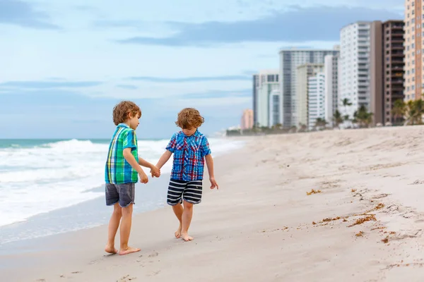 Due ragazzini che corrono sulla spiaggia dell'oceano — Foto Stock