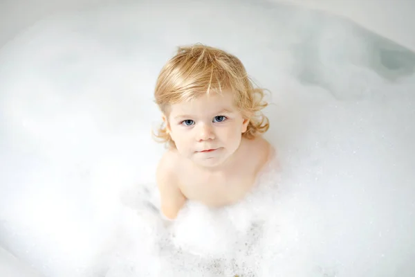 Roztomilé roztomilé malé batole dívka s koupel ve vaně. Šťastné zdravé dítě dítě hraje s hračkami gum guma a baví. Praní, čištění, hygiena pro děti. — Stock fotografie