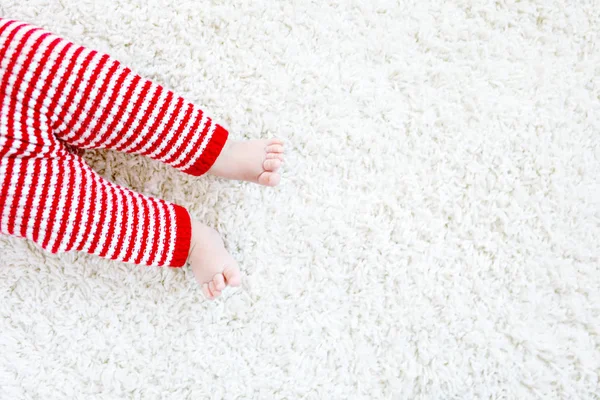 赤ちゃんの体とクリスマスには赤いサンタ クロース ズボンの脚のアップ — ストック写真