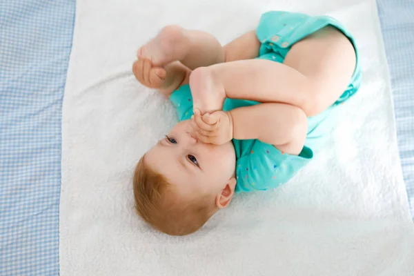 Lindo bebé tomando pies en la boca. Adorable niña chupando el pie . —  Fotos de Stock