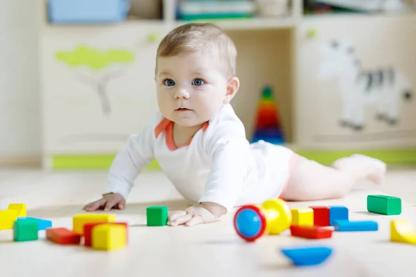 Schattige babymeisje spelen met kleurrijke rammelaar speelgoed — Stockfoto