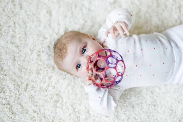 Linda niña jugando con colorido juguete sonajero — Foto de Stock