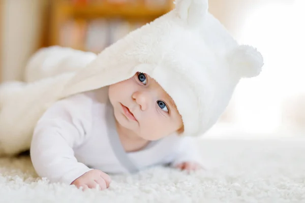 Menina bebê vestindo toalha branca ou overal de inverno no quarto ensolarado branco — Fotografia de Stock