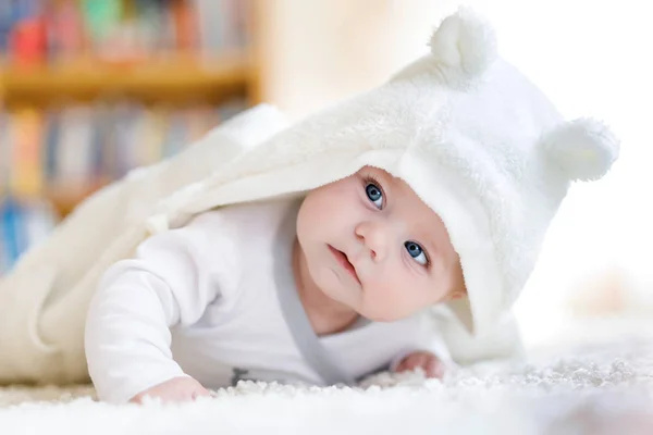 Meisje van de baby dragen witte handdoek of winter overal in witte zonnige slaapkamer — Stockfoto