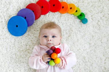 Renkli ahşap çıngırak oyuncakla oynamak sevimli bebeğim