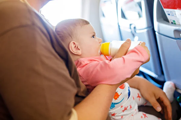 Padre che tiene in braccio sua figlia durante il volo in aereo in vacanza — Foto Stock