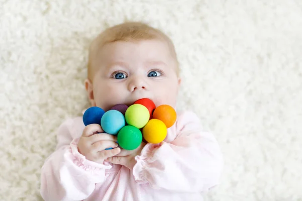 Cute baby girl playing with colorful wooden rattle toy — Stock Photo, Image