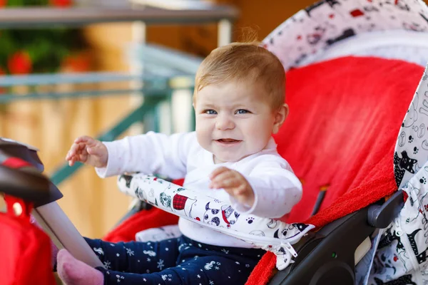 Carino piccola bella bambina seduta nella carrozzina o passeggino e in attesa di mamma. Felice bambino sorridente con gli occhi azzurri . — Foto Stock