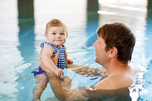 Glücklicher Vater mittleren Alters schwimmt mit süßen entzückenden kleinen Mädchen im Schwimmbad. — Stockfoto