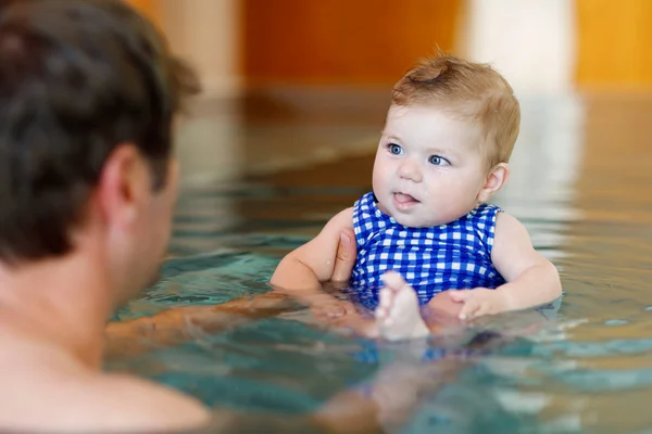 Feliz padre de mediana edad nadando con linda niña adorable en la piscina. — Foto de Stock