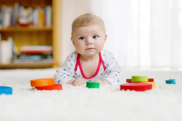 Bonito bebê menina brincando com colorido brinquedo chocalho de madeira — Fotografia de Stock