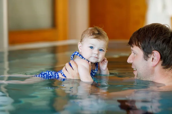 Happy w średnim wieku ojciec pływanie z cute uroczy dziewczynka w basenie. — Zdjęcie stockowe