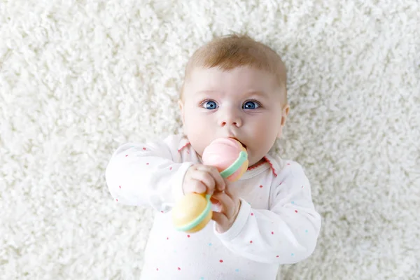 Bonito bebê menina jogar com colorido pastel vintage chocalho brinquedo — Fotografia de Stock