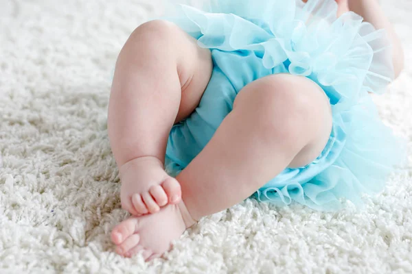 Fechar as pernas e os pés da menina no fundo branco usando saia de tutu turquesa . — Fotografia de Stock