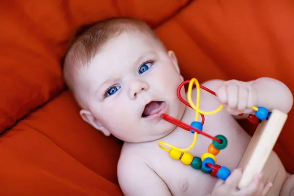 Adorabile neonato che gioca con il giocattolo di sonaglio educativo in legno colorato — Foto Stock