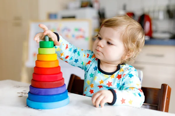 Adorabile carino bella bambina che gioca con educativo piramide giocattolo in legno arcobaleno — Foto Stock