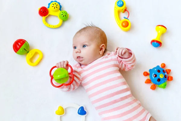 Cute baby girl playing with colorful rattle toys — Stock Photo, Image