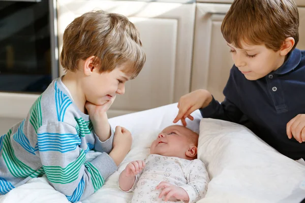 Two little kids boys playing with newborn baby sister girl — Stock Photo, Image