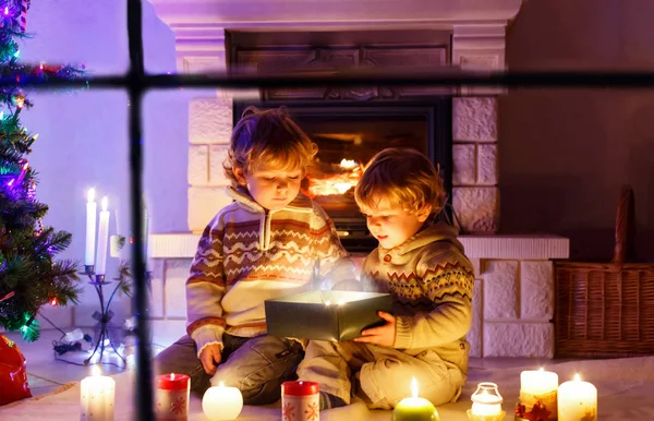 Niedliche Kleinkinder, blonde Zwillinge, die zusammen spielen und an Weihnachten Überraschungsgeschenkschachteln öffnen — Stockfoto