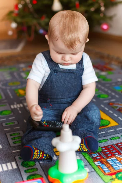 Bonito menino brincando na frente da árvore de Natal . — Fotografia de Stock