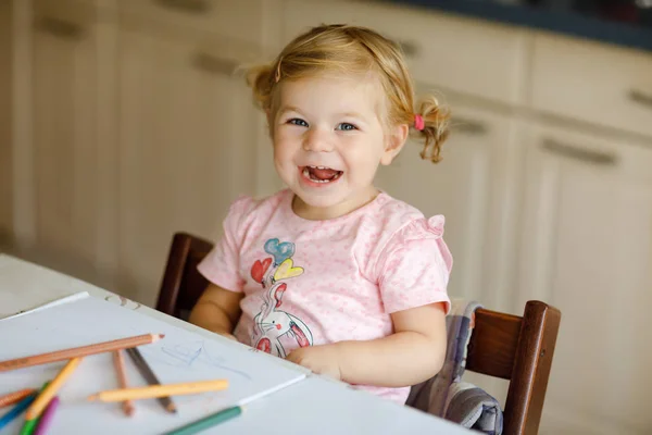 Милая очаровательная девочка учится рисовать карандашами. Маленький ребенок рисует дома, используя цветные ручки для наконечников войлока. Здоровая счастливая дочь экспериментирует с цветами дома или в детской. — стоковое фото