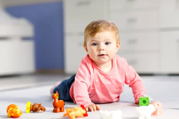 Adorable baby girl playing with domestic toy pets like cow, horse, sheep, dog and wild animals like giraffe, elephant and monkey. Happy healthy child having fun with colorful different toys at home — Stock Photo, Image