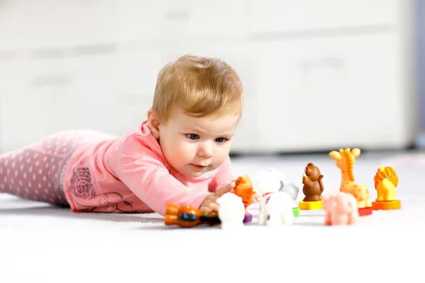 Schattig babymeisje dat speelt met huisdieren zoals koe, paard, schaap, hond en wilde dieren zoals giraffe, olifant en aap. Gelukkig gezond kind hebben plezier met kleurrijke verschillende speelgoed thuis — Stockfoto