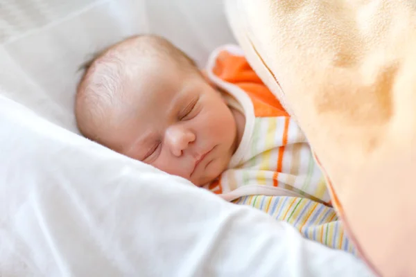 Sevimli, tapılası yeni doğmuş bebek yatakta huzur içinde uyuyor. Yeni doğmuş bir çocuk, yatakta yatan küçük bir kız. Aile, yeni hayat, çocukluk, başlangıç konsepti — Stok fotoğraf