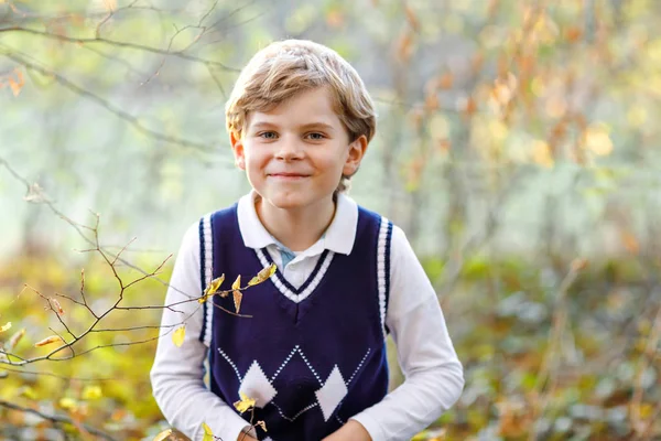 Portrait of little cool kid boy in forest. Happy healthy child having fun on warm sunny day early autumn. Family, nature, love and active leisure. Kid in school uniform. — Stock Photo, Image
