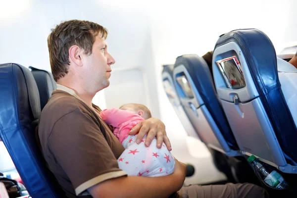 Joven padre cansado y su hija bebé durmiendo durante el vuelo en avión de vacaciones — Foto de Stock