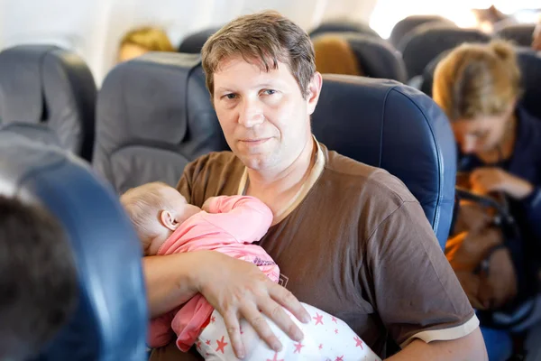 Young moe vader en dochter baby slapen tijdens de vlucht op het vliegtuig op vakantie te gaan — Stockfoto