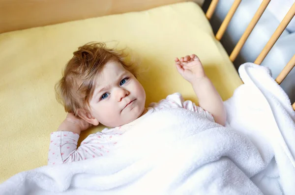 Cute little baby girl lying in cot before sleeping. Happy calm child in bed. Going sleep. Peaceful and smiling child — Stock Photo, Image