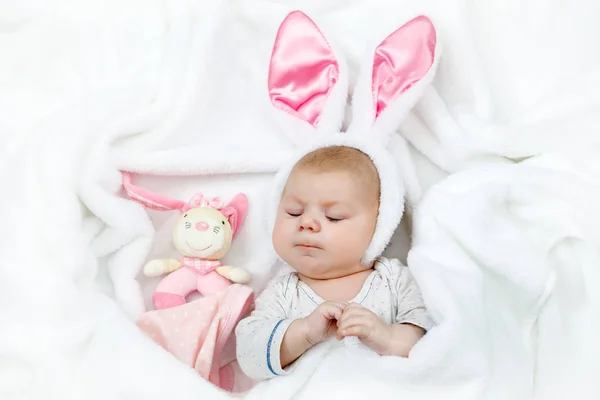 Adorável menina recém-nascido bonito em traje de coelho de Páscoa e orelhas. Linda criança brincando com brinquedo de coelho de pelúcia. Conceito de férias.. — Fotografia de Stock