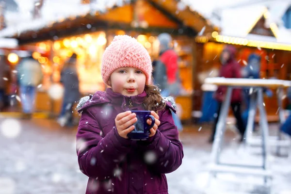 Kleine schattige jongen meisje met kopje warme chocolademelk of kinderen punch stomen. Gelukkig kind op de kerstmarkt in Duitsland. Traditionele ontspanning voor gezinnen op Kerstmis. — Stockfoto