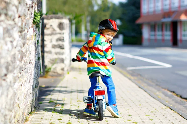 Mały, słodki chłopiec na rowerze latem lub w autmn dniu. Zdrowe szczęśliwe dziecko bawiące się na rowerze. Aktywny wypoczynek dla dzieci. Bezpieczny hełm na głowie chłopców. W kolorowych ubraniach — Zdjęcie stockowe